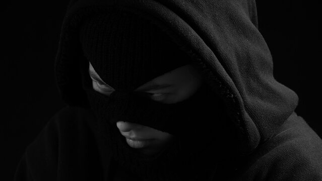 Masked female burglar in black look. Crime concept