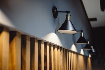 Black lamps indicate a gray wall decorated with wooden lines, background for interior design....
