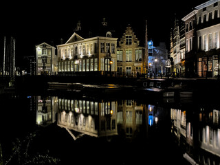 Fototapeta premium illuminated buildings reflecting into the water of river Lys, touristic view in the city of Ghent, Flanders, Belgium