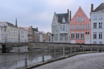 Naklejka premium Old medieval houses along a canal on a winter morning in Bruges, Flanders, Belgium