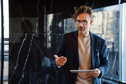 Mature Manager Using Tablet Computer During Offline Meeting