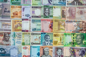 Various African banknotes stacked on top of each other forming a money background.