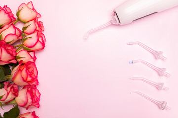 Happy International Dentist Day rose flowers, oral teeth irrigator on pink background mockup. Dental care. Greeting card for professional holiday. Copy space, horizontal. 