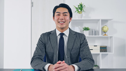 カメラ目線で話すビジネスマン　ビデオ通話　インタビュー