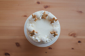 Christmas cake with coconut candies and cookies on a ceramic stand