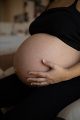 Pregnant female caressing her belly. Prenatal concept. Very close-up. Hand on belly