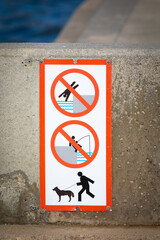 Señal en un puerto de: prohibido nadar o tirarse al agua, prohibido pescar, perro atado.