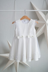 White festive dress hanging on a wooden hanger