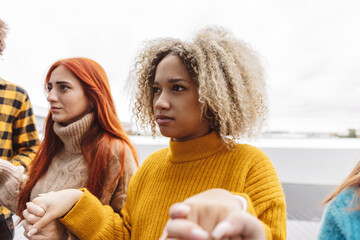 Woman with curly hair holding hands with each other at protest