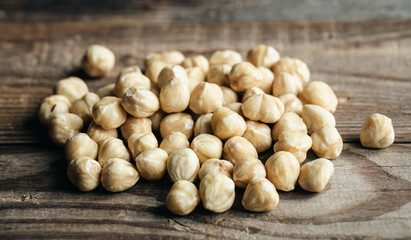 Heap of roasted hazelnuts close-up on a wooden background.