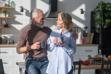 Mature couple having morning coffee andtalking in the kitchen