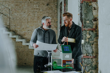 Architect and customer discussing over blueprint at construction site