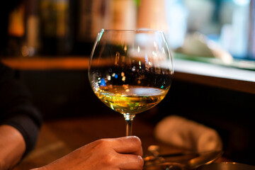 カウンターで白ワインを飲む