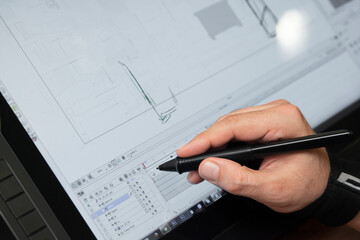 man holding a tablet and drawing with a pen in his hand