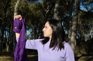 Feminist woman with a raised fist and a lilac scarf. Feminism and equality rights concept.
March 8, International Women's Day