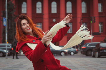 Obraz premium Close up joyful woman with long scarf on street portrait picture. Closeup side view photography with urban buildings on background. High quality photo for ads, travel blog, magazine, article