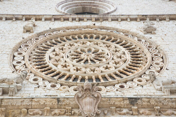 Medieval italian rose window against a stone wall - Italy - Assi