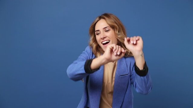 Young fancy vivid happy bright woman wear classic suit jacket beige t-shirt dance waving rising have fun enjoy relax celebrate play fluttering hair isolated on plain dark royal navy blue background