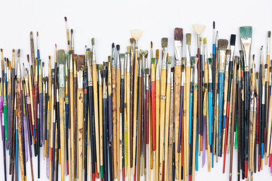 Many brushes for painting on a white background, top view.