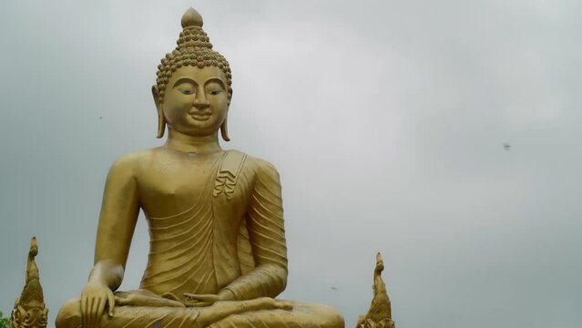 Close-up of the largest Buddha in Thailand in a golden robe in the lotus position. Deity is located on the territory of the monastery, unique statue is the main attraction of Thailand.