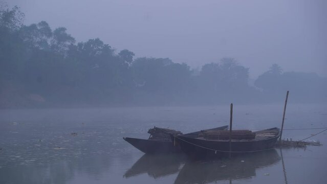 There are boats tied to the river at dawn of winter