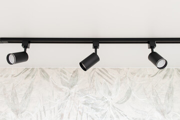 Modern track spot Light on white stretch ceiling in interior