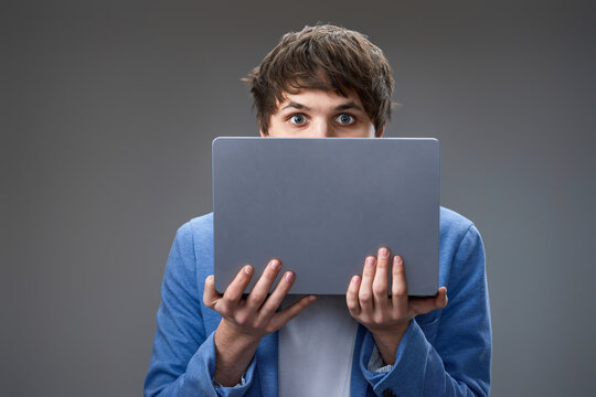 young man hiding his face with laptop
