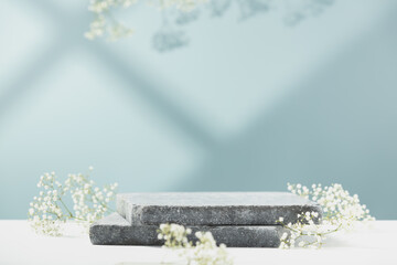 Flat granite pedestal and white flowers on blue background.  Showcase for cosmetic products. Product advertisement. Layout style design.