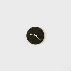 Black clock on white wall. Minimalist home interior design decoration. Time concept