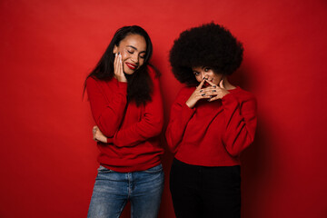 Two young african american women smiling and posing at camera