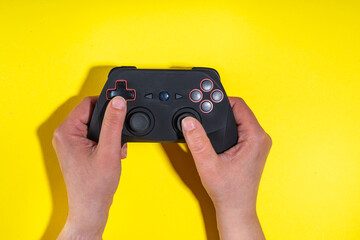 Gamer simple bright background, male hands flat barking on yellow background with classic game...