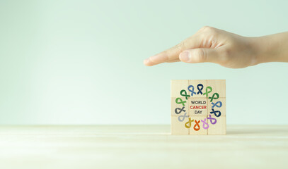 World cancer day (February 4). Colorful ribbons on wooden cube blocks background, cancer awareness, national cancer survivor day. Healthcare and medical concept.