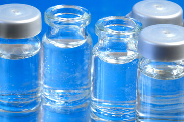 bottles of vaccine on blue background, production medicine vaccine