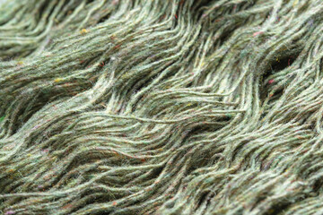 Threads of natural organic sheep wool. Unwound skein of olive green knitting yarn.