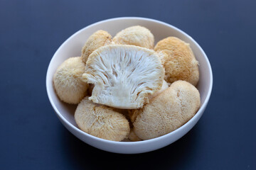 Fresh lion's mane mushroom on dark background.