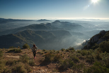 Obraz premium Woman runs through the mountains of Montserrat in Catalonia, Spain.