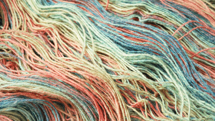 Threads from natural organic sheep wool. Unwound skein of multicolor rainbow knitting yarn.