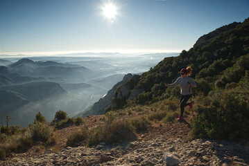 Obraz premium Woman runs through the mountains of Montserrat in Catalonia, Spain.