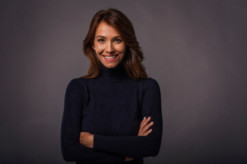 Studio portrait of attractive brunette haired woman posing at isolated background