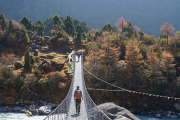 A hiker crosses a hanging bridge on the Kanchenjunga base camp trek in Nepal to Ghunsa during...
