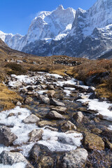 Fototapeta na wymiar A frozen stream along the track to Jannu peak viewpoint, one of the highlights of the Kanchenjunga base camp trek in Nepal.