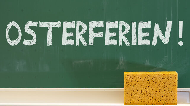 Gr&uuml;ne Kreidetafel Schultafel, mit der Aufschrift: OSTERFERIEN !