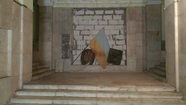 Kharkiv, Ukraine - December 2022: Destroyed symbols of Ukraine. Coat of arms of Ukraine in a destroyed house.