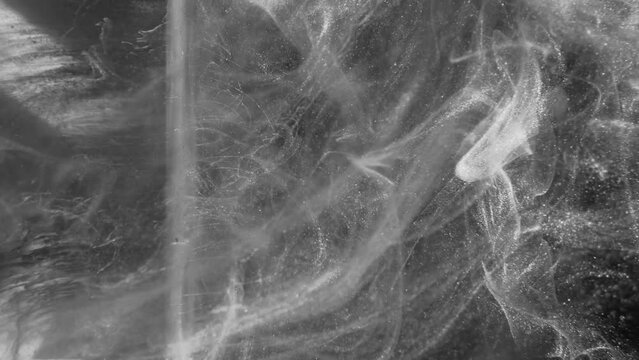 Glitter mist. Ink splash. Vapor texture. Gray white sparkling shiny steam floating motion on dark black monochrome abstract background.