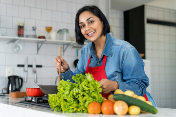 Happy hispanic woman preparing vegetarian or vegan food