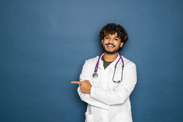 Male doctor with fineger point aside isolated on blue background
