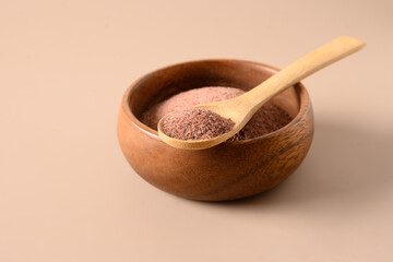 Indian Black salt, Kala namak in wooden bowl and spoon on beige background. Ideal for Indian cuisine. Close up. Copy space.