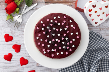 Blueberry cheesecake decorated with sweet hearts on wooden table. Top view