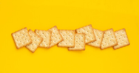 Dry cracker cookies on yellow background.