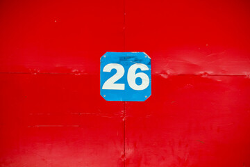 The number twenty six on a red background is at the gate